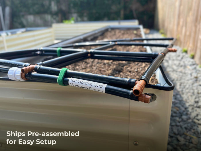 Garden Grid Watering System in pre-assembled sections strapped together resting on the edge of a raised garden bed with a label reading The Garden Grid Watering System and a callout saying Ship pre-assembled for easy setup