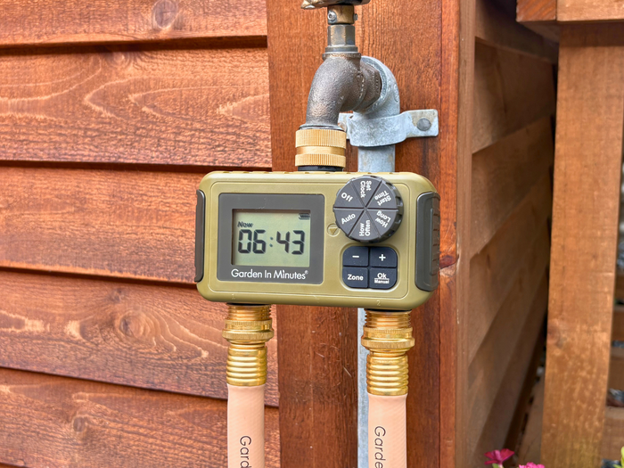 Garden In Minutes two zone timer attached to an outdoor spigot with two hoses connected
